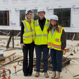 three people posing for a picture at a construction site
